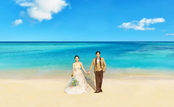 青い海と白い砂浜の中の新郎新婦