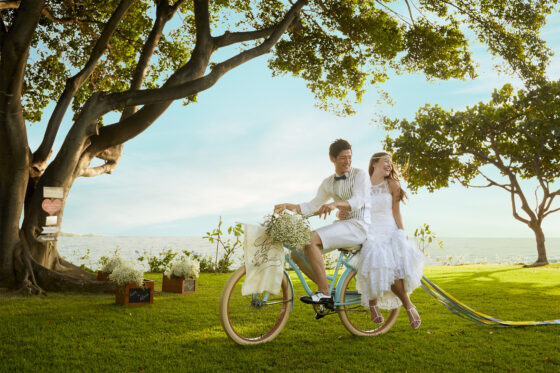 緑の中自転車に乗る新郎新婦