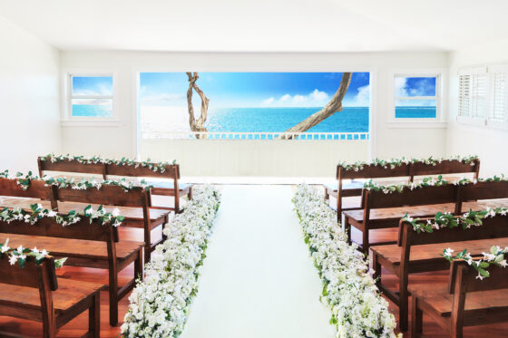 ハワイらしい結婚式会場でウェディングフォト。美しい邸宅をチャペル風にして、贅沢な時間が流れる。フラワーアレンジメントも華やか。