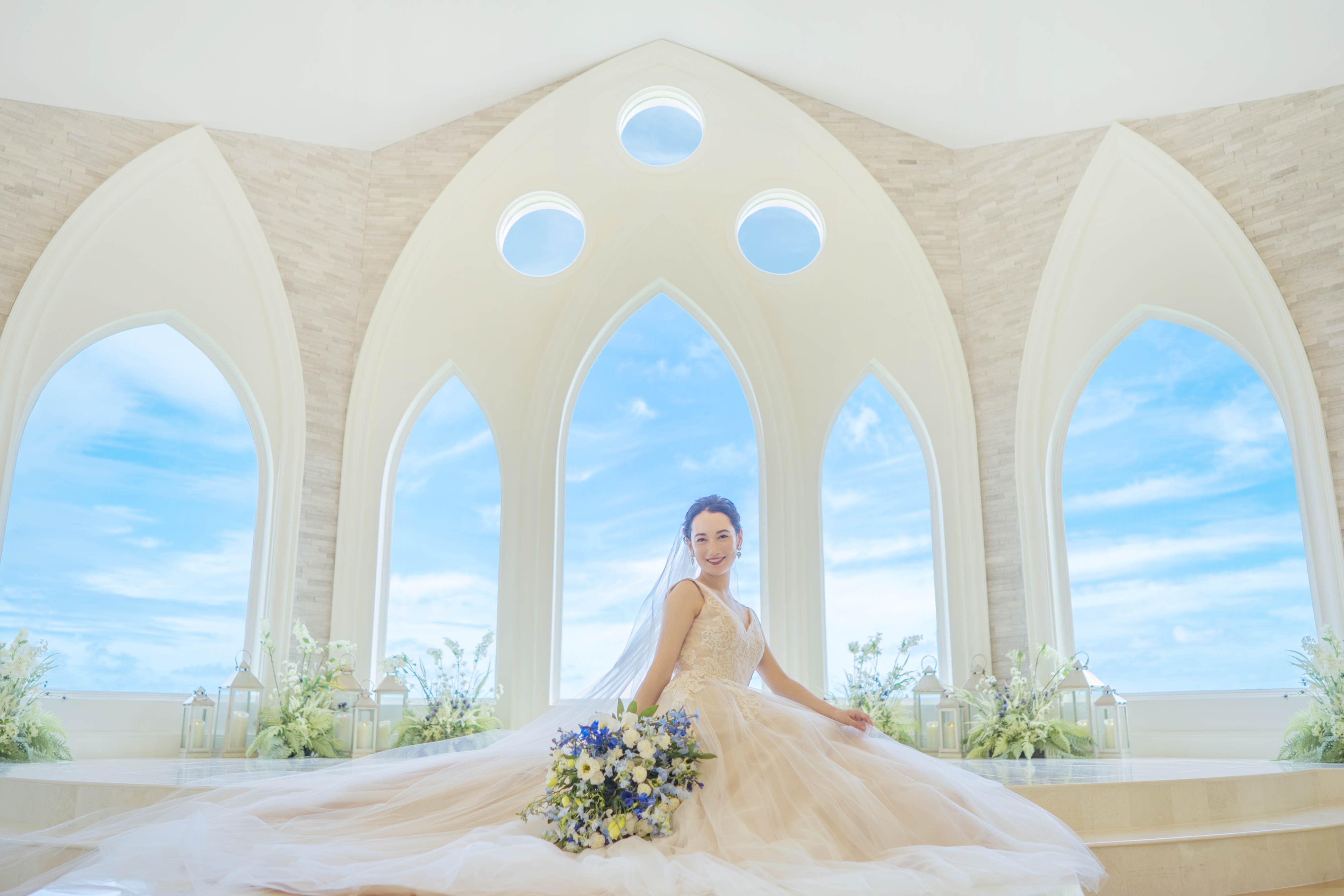 真っ白なチャペルで構図の美しい１枚。ふんわりとウエディングドレスを広げて座る新婦はまるでプリンセス。