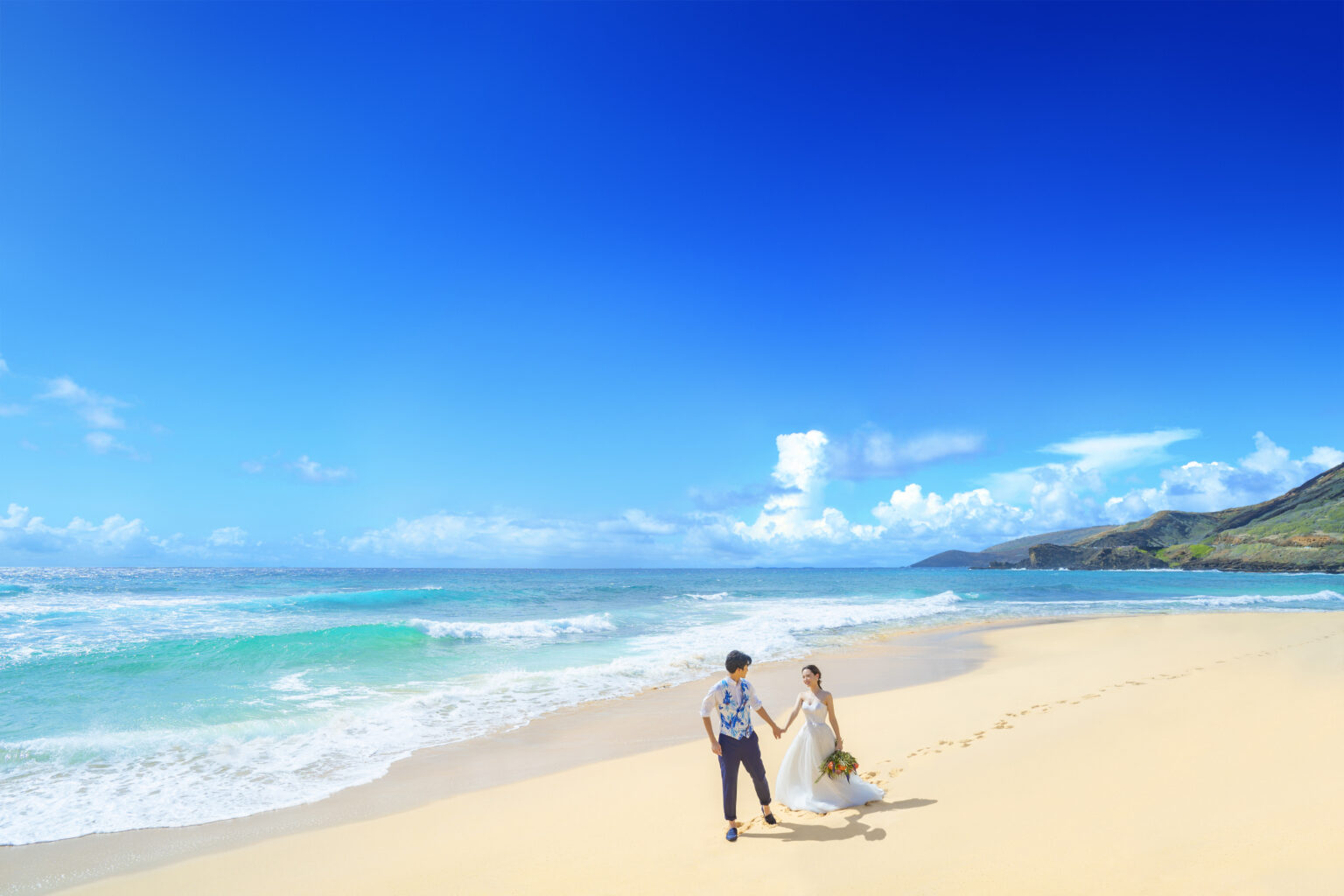青い海と空、真っ白な砂浜の美しいビーチに続く2人の足跡。その光景はまるで絵画のように美しい。
