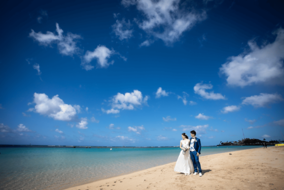 青い海を眺める砂浜の新郎新婦