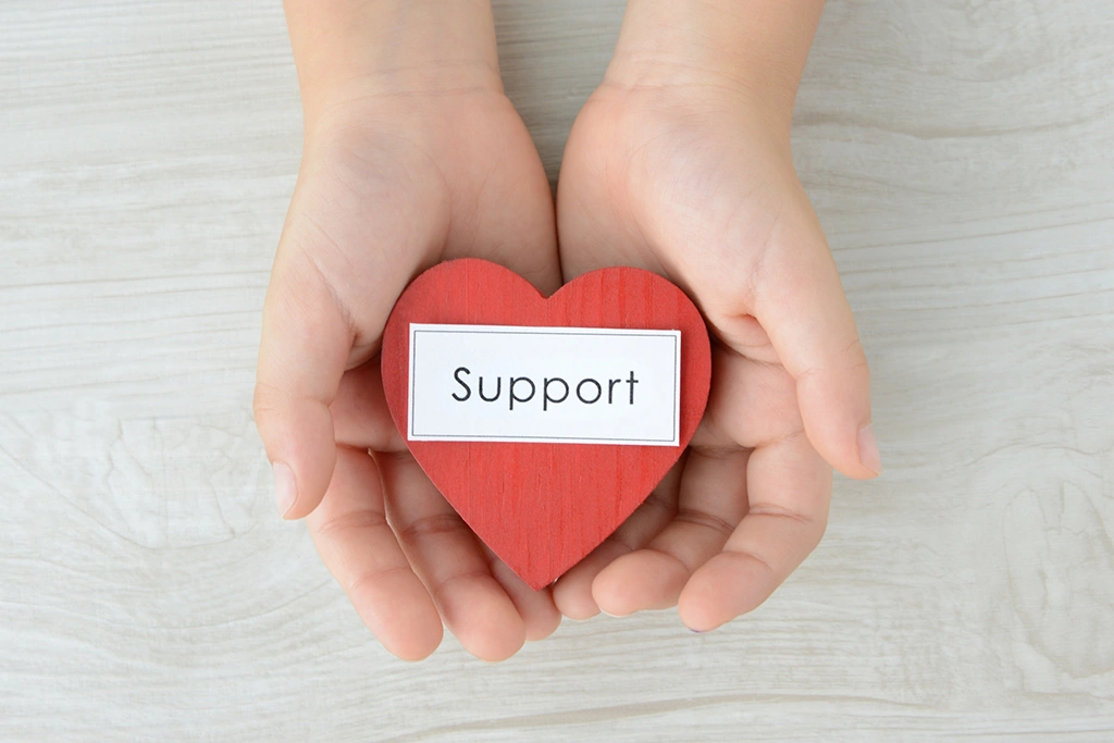 両手に載った「support」という文字の書いてあるハート