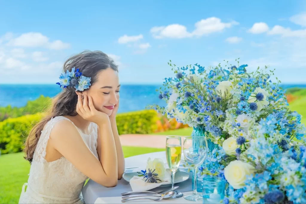 青い海と空を背景に、沖縄の自然を感じながらリラックスする花嫁の横顔