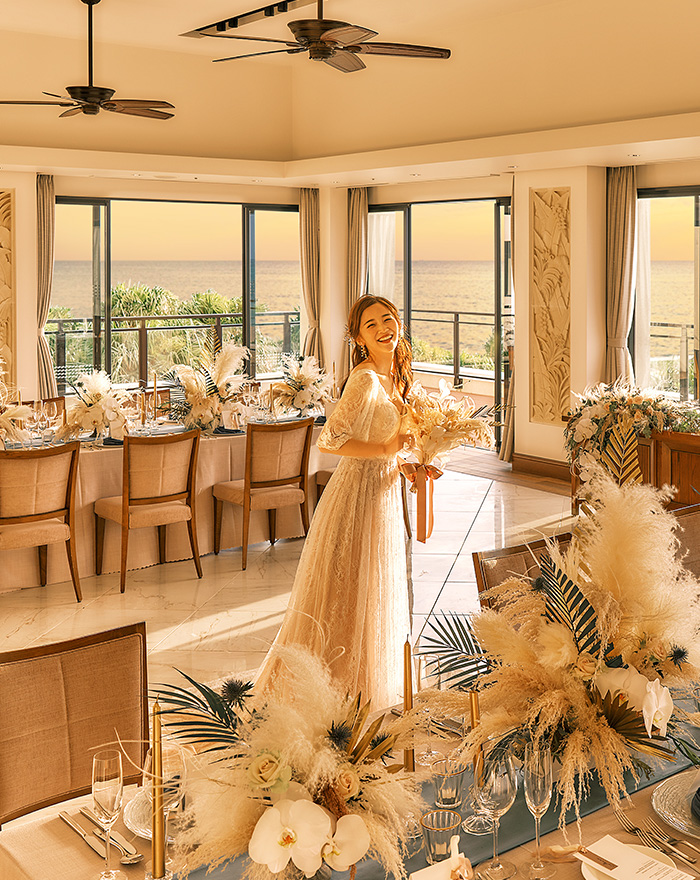 写真:装花アーチの下でブーケを手に振り向く笑顔の新婦