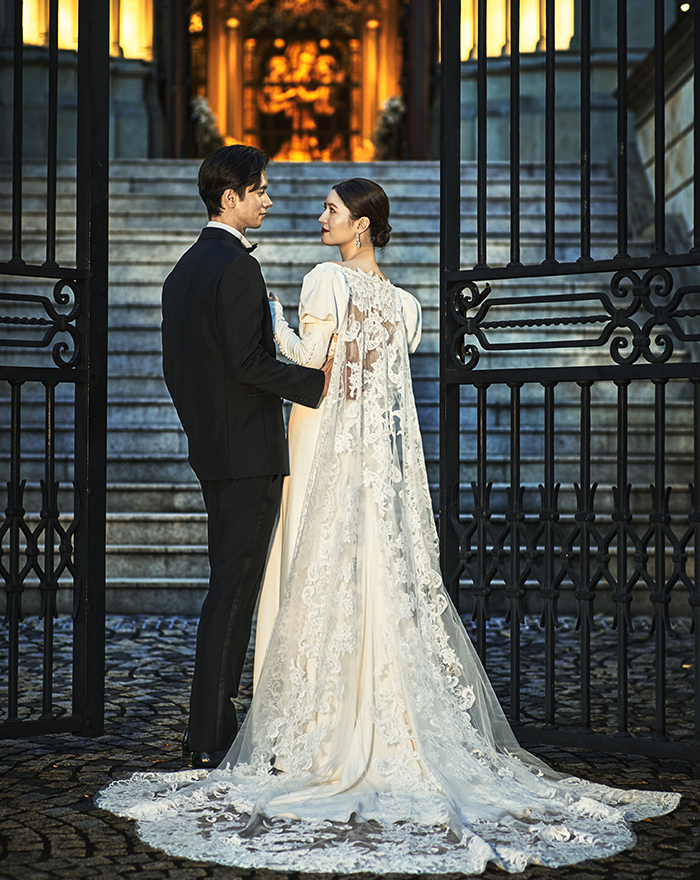 写真:腕を組み互いを笑顔で見つめ合う新郎新婦