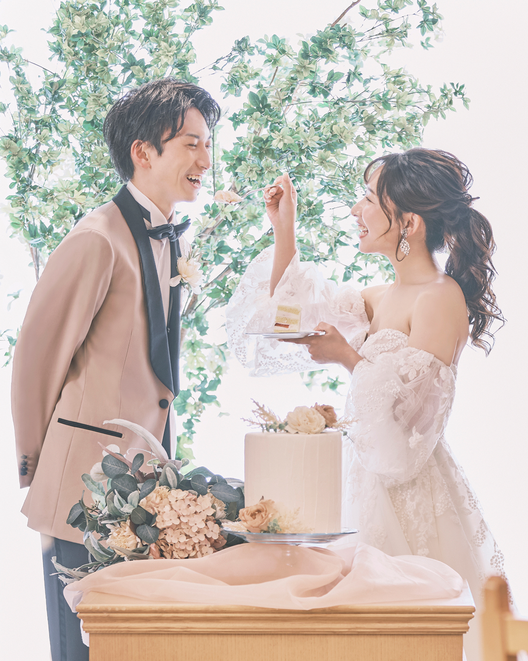 写真：腕を組みお互いを笑顔で見つめ、フラワーシャワーの中を歩く新郎新婦