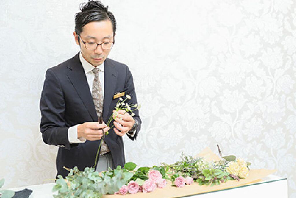 写真:音響機材の前で笑顔でカメラ目線の梅嶋