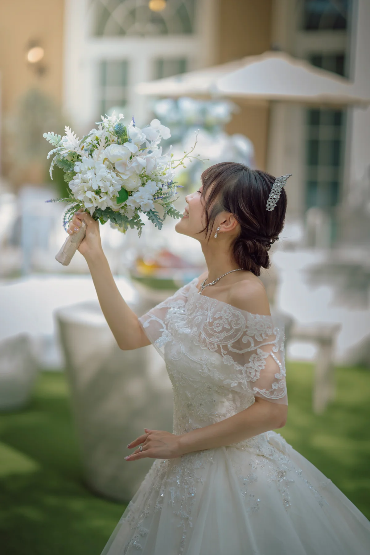 庭園でブーケを見つめる花嫁